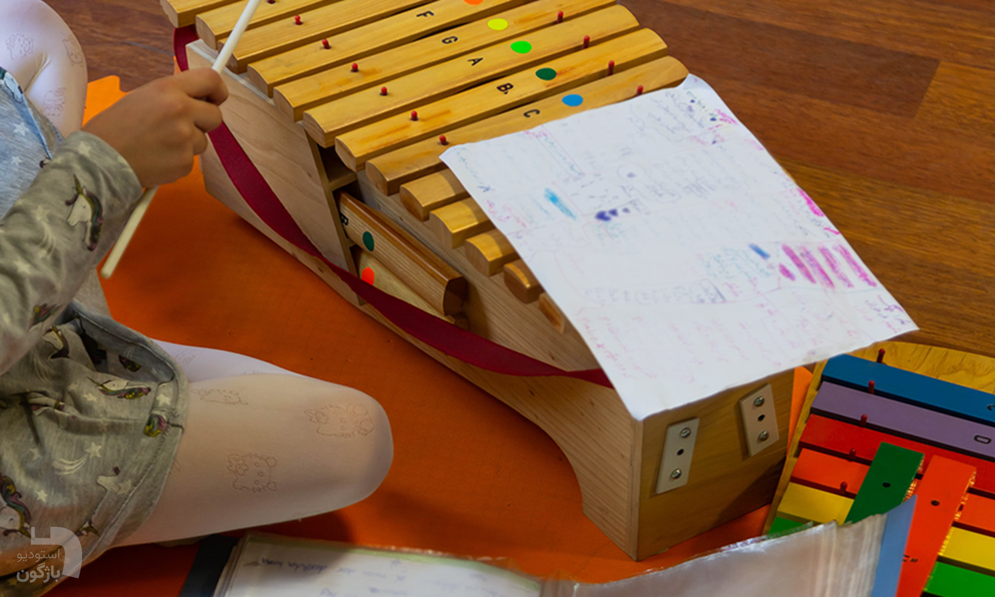 کلاس‌های موسیقی کودک بهتاش داورپناه در غرب تهران - هنرجو با زایلوفون و یادداشت نت نویسی